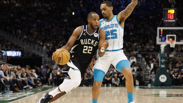 Milwaukee Bucks forward Khris Middleton (22) drives for the basket around Charlotte Hornets forward P.J. Washington (25)